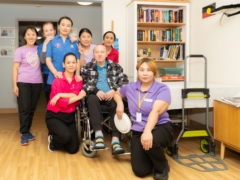 Staff and residents posing together to commemorate the Aged Care Employee Day celebration.