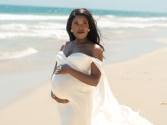 Expecting parents sitting on the grass at Cottesloe Civic Centre, sharing a joyful moment
