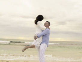 Romantic kiss on the shore with waves splashing at Trigg Beach, WA.